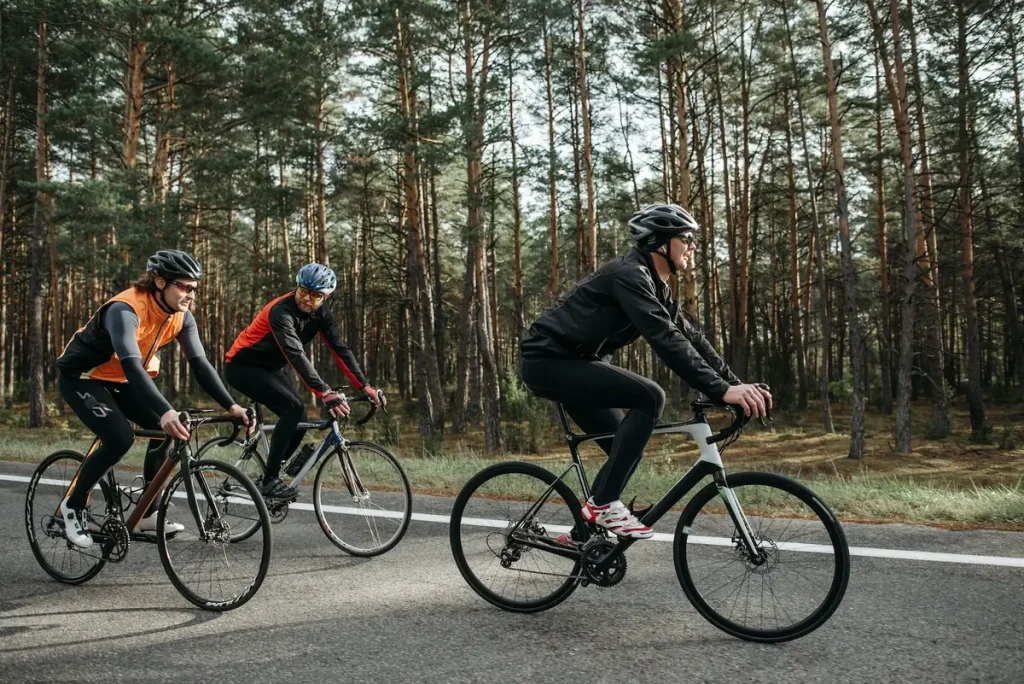 Three cyclists riding along a forest road for endurance training